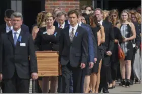  ?? BRYAN WOOLSTON — THE ASSOCIATED PRESS ?? The casket of Otto Warmbier is carried from Wyoming High School followed by his father, Fred Warmbier, center, after the funeral, Thursday in Wyoming, Ohio. Otto Warmbier, a 22-year-old University of Virginia undergradu­ate student who was sentenced in March 2016 to 15 years in prison with hard labor in North Korea, died this week, days after returning to the United States.