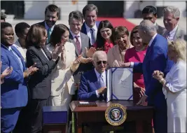 ?? EVAN VUCCI — THE ASSOCIATED PRESS ?? President Joe Biden holds the “CHIPS and Science Act” after signing it on the South Lawn of the White House on Tuesday.