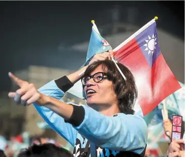  ?? ?? Centre of attraction: Hou being greeted by supporters in Kaohsiung. (right) a supporter holds Taiwan’s national flag and the TPP campaign flag during a rally in Taichung. — AFP