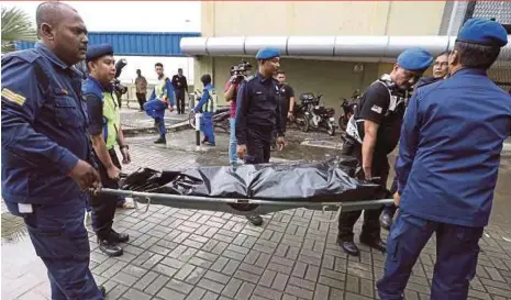  ?? JAMALUDIN PIC BY MOHD AZREN ?? Rescuers taking a drowning victim for a post-mortem in Kota Tinggi yesterday.