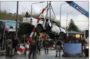  ?? (AP/Rahmat Gul) ?? A damaged vehicle is removed after a bombing in Kabul, Afghanista­n, in March.