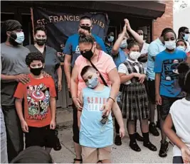  ?? JESSIE WARDARSKI/AP ?? Students and family gather Thursday at St. Francis Xavier School in Newark, New Jersey, a week after the Archdioces­e of Newark announced the school would close permanentl­y.