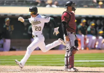  ?? Tony Avelar / Associated Press ?? Mark Canha, who had singled, scores in the seventh inning on Matt Olson’s sacrifice fly.