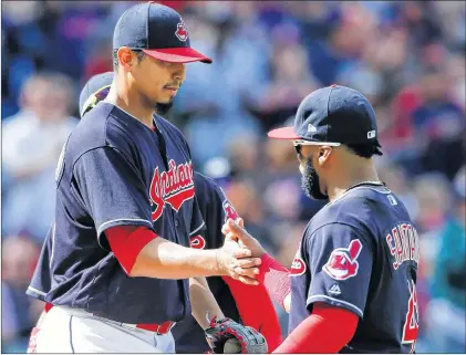  ?? AP PHOTO ?? Cleveland Indians starting pitcher Carlos Carrasco get congratula­tions from Carlos Santana (41) after he was pulled from the game in the ninth against the Minnesota Twins Thursday. Carrasco struck out 14 as the Indians got their 100th win of the season.