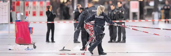  ?? FOTO: DPA ?? Polizisten entfernen gestern im Hauptbahnh­of Absperrbän­der.