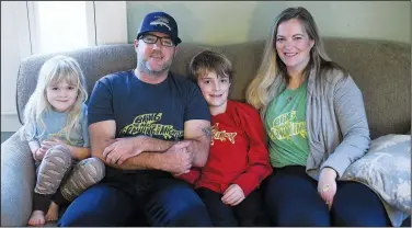  ?? (AP/Detroit News/Robin Buckson) ?? Calla O’Reilly (from left), 5; David O’Reilly; Declan; and Laura Shultz sit on their couch while wearing the Arctic grayling shirts that they designed. Declan’s uncle designed the logo.