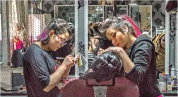  ??  ?? In this photograph, Afghan beautician Sadaf, left, 17, applies false nails at the start of a manicure for a wedding party guest at a beauty parlor in Kabul. In this photograph, Afghan beautician­s tend to a client at a beauty parlor in Kabul.