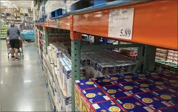  ?? (AP PHOTO/DAVID ZALUBOWSKI) ?? A shopper guides a cart past a line of gigantic boxes of breakfast cereals in a Costco warehouse on Thursday, June 17, 2021, in Lone Tree, Colo. Inflation at the wholesale level jumped 1% in June, pushing price gains over the past 12months up by a record 7.3%. The Labor Department reported Wednesday, July 14that the June increase in its producer price index, which measures inflation pressures before they reach consumers, followed a gain of 0.8% in May and was the largest one-month increase since January.