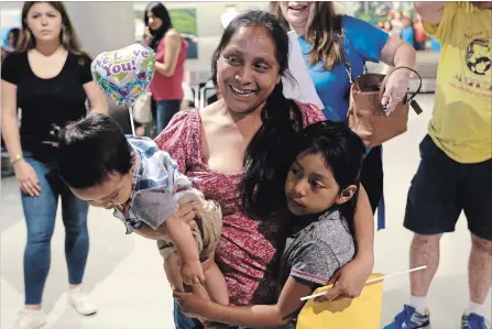  ?? LYNNE SLADKY THE ASSOCIATED PRESS ?? Buena Ventura Martin-Godinez holds her son Pedro, left, as she is reunited with her daughter Janne, right, at Miami airport, Sunday. Martin crossed the border from Mexico in May with her son, fleeing violence in Guatemala. Her husband crossed two weeks...