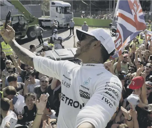  ??  ?? 0 A jubilant Lewis Hamilton takes a selfie with supporters after his triumph in the Italian Grand Prix at Monza on Sunday.