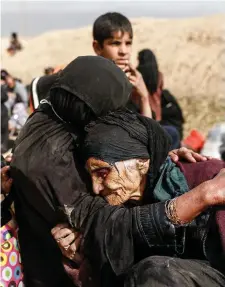  ??  ?? An elderly woman is comforted by a relative as displaced families flee their homes as Iraqi forces battle with Isil militants in western Mosul. Photo: Reuters/Zohra Bensemra