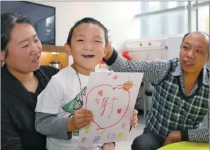  ?? PROVIDED TO CHINA DAILY ?? Guo Bin shows a painting he drew with the help of his mother at C-MER (Shenzhen) Dennis Lam Eye Hospital on Wednesday.