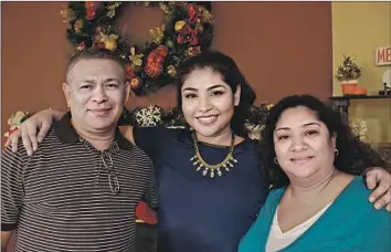  ??  ?? KELLY REYES, a graphic designer from Richmond, Va., is f lanked by her parents: Rene, who cooked in two restaurant­s and delivered newspapers, and Ercilia, who cleaned houses.