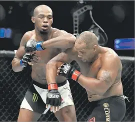  ?? Sean M. Haffey Getty Images ?? JON JONES, shown elbowing Daniel Cormier during UFC 214, will likely have to wait until early 2018 to get a much-desired bout against Brock Lesnar.