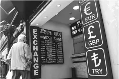  ??  ?? A man looks to a board displaying US dollars and Euros exchange rates in Turkish liras on May 23, at a exchange office in Istanbul. Turkey’s embattled lira hit new historic lows against the US dollar after suffering a hammering in Asian trade, as...