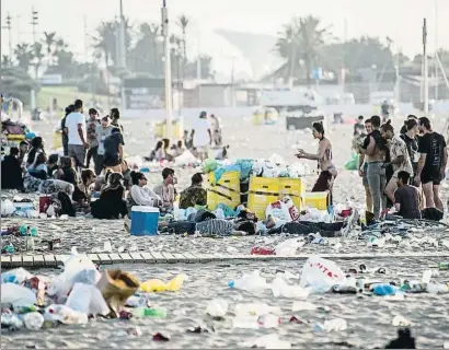  ?? XAVIER CERVERA ?? Varias personas apuraron los últimos compases de la fiesta en la Nova Icària entre un mar de basura