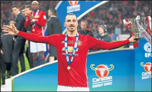  ??  ?? Zlatan Ibrahimovi­c holds the League Cup aloft after his starring role in the 3-2 victory over Claude Puel’s Saints at Wembley Stadium yesterday