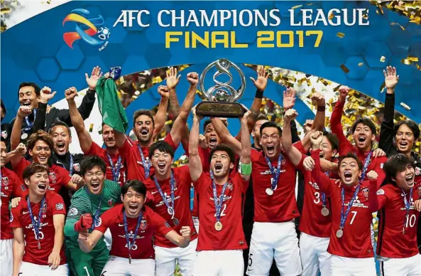  ??  ?? Best of Asia: Urawa Red Diamonds players posing with the trophy after winning the AFC Champions League final at the Saitama Stadium in Japan yesterday. Urawa win 2-1 on aggregate. — Reuters