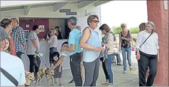  ??  ?? Les parieurs font la queue au guichet