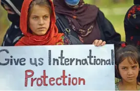  ?? (AFP) ?? Afghans hold a placard as they gather to demand help from the United Nations High Commission­er for Refugees (UNHCR) for asylum abroad, in Islamabad on May 12, this year