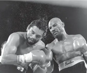  ?? AP FIle Photos ?? CHAMP: Marvelous Marvin Hagler celebrates following his victory by unanimous decision over Roberto Duran in November 1983. Right, sweat flies off Roberto Duran as Marvin Hagler lands a punch in the ninth round.