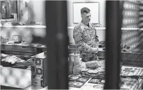  ??  ?? Army Capt. Geoffrey C. Mattoon stands among examples of deceased service members’ belongings last month at the Joint Personal Effects Depot on Dover Air Force Base, Delaware.