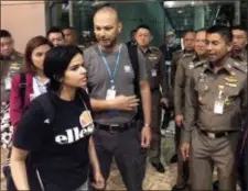  ?? IMMIGRATIO­N POLICE VIA AP ?? In this photo released by the Immigratio­n Bureau, Saudi woman Rahaf Mohammed Alqunun, foreground walks by Chief of Immigratio­n Police Maj. Gen. Surachate Hakparn, right, before leaving the Suvarnabhu­mi Airport in Bangkok Monday.