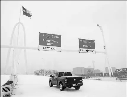  ?? JEFFREY MCWHORTER / THE NEW YORK TIMES ?? As a winter storm hits Thursday, a truck drives across the Margaret Hunt Hill Bridge in Dallas. The storm arrived in Texas almost exactly a year after a weeklong freeze led to the deaths of more than 200 people and caused widespread power outages in the Lone Star State. Gov. Gregg Abbott assured the state’s 29 million residents Thursday that the power grid was expected to hold, though as many as 45,000 outages had been reported in the early afternoon hours in Texas.