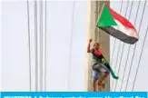  ?? — AFP ?? KHARTOUM: A Sudanese protester waves his national flag in front of the Algerian embassy as people celebrate in Khartoum, after Sudan’s army rulers and protest leaders signed a hard-won constituti­onal declaratio­n.