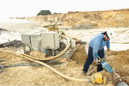  ?? Houston Chronicle via AP ?? n Julio Griffin adjusts the water pressure on a hydro-cannon at the Superior Silica Sands sand mine on March 28 in Kosse, Texas. Demand for sand is surging as oil and gas production in the Permian Basin is booming again. Not only is the need for more...