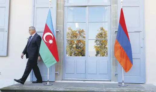  ?? EUTERS ?? A security guard walks past an Azerbaijan­i (L) and Armenian flag at the opening of talks of the Organizati­on for Security and Co-operation in Europe (OSCE) Minsk Group in Geneva, Switzerlan­d, Oct. 16, 2017.