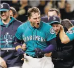  ?? Elaine Thompson / Associated Press ?? Logan Morrison emerges from a crowd of teammates who celebrated his game- ending 11th- inning home run.