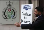  ?? FRANK AUGSTEIN — AP PHOTO ?? Yaseen Islam, Uber driver and president of the App Drivers & Couriers Union, poses with a poster outside the Supreme Court in London on Frida. The U.K. Supreme Court ruled that Uber drivers should be classed as “Aitworkers” and not self employed.