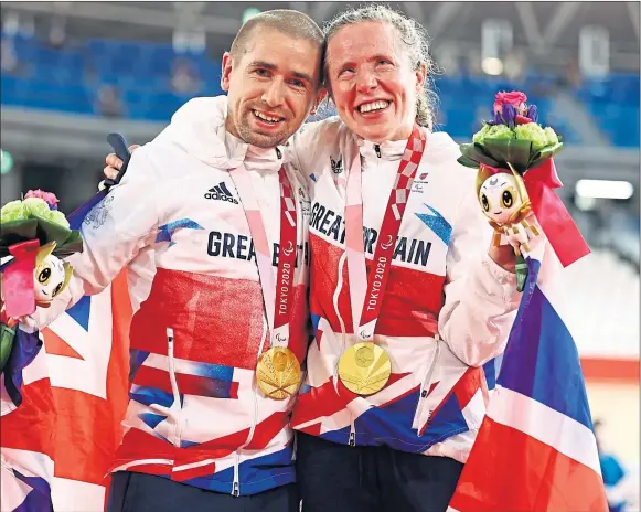  ??  ?? Neil and Lora Fachie celebrate their two gold medals and world record times at the Paralympic­s in Tokyo yesterday
