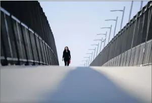  ?? AP PHOTO ?? A woman walks towards the border on a pedestrian bridge over constructi­on on a new curve along California’s Interstate 5, as it approaches the border with Tijuana, Mexico, in San Diego.