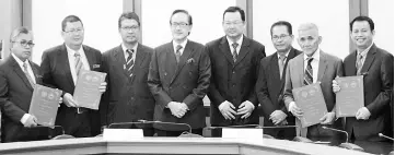  ??  ?? Masidi (fourth left), Kamarlin (third left) and Pang (fourth right) with representa­tives from DBP and Sabah Parks officials after the MoU signing ceremony yesterday.