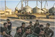  ?? Mauricio Lima / New York Times 2015 ?? Kurdish fighters walk by tanks in 2015 used by Islamic State after a battle near Tel Tamer, Syria.