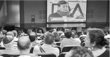  ??  ?? People watch a screen showing Colombia’s ELN guerrilla member Pablo Beltran during the transmissi­on of the beginning of the peace talks between the Colombian government and the ELN guerrilla-taking place in Quito-, at Memory museum in Medellin,...