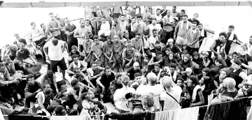  ??  ?? Migrants listen to a speech on board the MV Aquarius as the rescue ship navigates toward the island of Malta. — Reuters photo