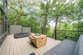  ?? Submitted photo ?? ■ The balcony of one of the cabins at In the Trees features a sitting area, a fire pit and a hot tub.