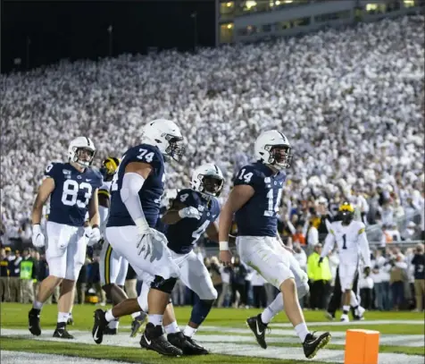  ?? Brett Carlsen/Getty Images ?? Quarterbac­k Sean Clifford, right, celebrates a touchdown run in the second quarter in front of a White Out game crowd at Beaver Stadium in University Park, Pa.