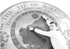  ??  ?? A biker showing the distance from Sibu to Tip of Borneo on the Globe.