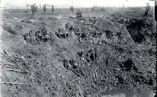  ?? ALEXANDER TURNBULL LIBRARY ?? New Zealand Engineers resting in a large shell hole at Ypres Salient, in October 1917.