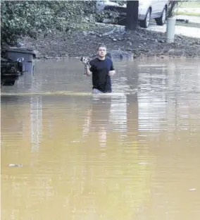  ?? (Photo: AP) ?? Michael Halbert wades through his flooded neighbourh­ood in Pelham, Ala, yesterday.