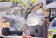  ?? WILFREDO LEE /ASSOCIATED PRESS ?? Workers use a backhoe Friday on a section of a pedestrian bridge that collapsed Thursday afternoon near Florida Internatio­nal University in the Miami area.