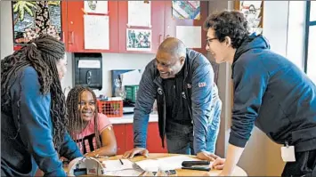  ?? ERIN HOOLEY/CHICAGO TRIBUNE ?? Former Bears player Mickey Pruitt and Walter Payton High School junior Jake Herman, right, help 17-year-old patient Diamond Johnson and her mother, Delilah Alexander, fill out a fantasy football roster at Lurie Children’s Hospital in Chicago.