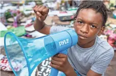  ?? ALTON STRUPP/USA TODAY NETWORK ?? Keshawn Johnson, 12, kneels while raising a fist at the Breonna Taylor mural in Louisville, Ky.