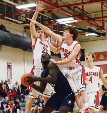  ?? OWEN MCCUE - MEDIANEWS GROUP ?? Phoenixvil­le’s Chris Weiah, center, looks toward the basket as Owen J. Roberts’ Sam Kuhl, left, and Tom McLean defend Tuesday.