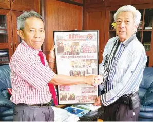  ?? Utusan Borneo ?? AWANG Damit (kiri) menerima keratan akhbar Johnson semasa pertemuan di Wisma MUIS pada Isnin. yang telah dibingkai daripada
