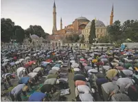  ?? EMRAH GUREL/ASSOCIATED PRESS ?? Muslims offer their evening prayers Friday outside the Byzantine-era Hagia Sophia, one of Istanbul’s main tourist attraction­s in Istanbul. Turkey’s highest administra­tive court issued a ruling that paves the way for the government to convert Hagia Sophia back into a Muslim house of worship.